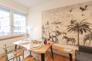 a dining room with a table and a wall mural at Juliusliving - modernes Wohnen an der Juliuspromenade in Würzburg