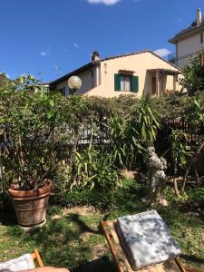 un giardino con una pianta in vaso e un dipinto di La Villa Bianca - appartamento in villa a Sesto Fiorentino