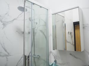 a glass shower in a bathroom with a mirror at Mercy Apartments A 12 in Warsaw