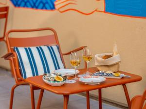 - une table avec deux verres de vin et de nourriture dans l'établissement Eklo Montpellier Centre Gare, à Montpellier