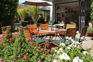 una mesa y sillas en un jardín con flores en Hotel Goldener Engel en Espira