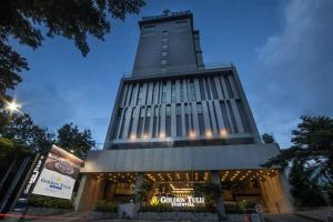 a building with a clock tower on top of it at Golden Tulip Essential Makassar in Makassar