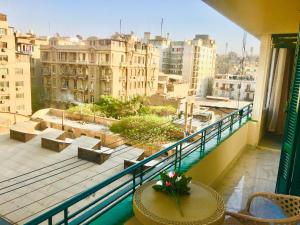 een balkon met een tafel en uitzicht op de stad bij Sweet Home Downtown Cairo in Caïro
