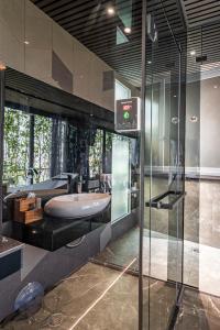 La salle de bains est pourvue d'un lavabo et d'une douche en verre. dans l'établissement Bonita Signature The View, à Hô-Chi-Minh-Ville