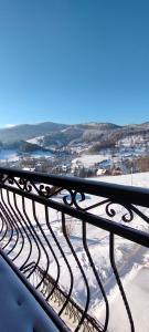 a metal bench with a view of a snowy city at Domek pod Lipą in Korbielów