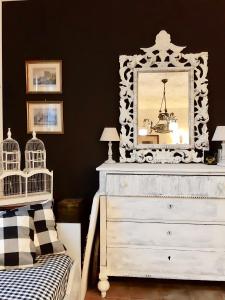 una camera da letto con cassettiera bianca e specchio di La Villa Bianca - appartamento in villa a Sesto Fiorentino