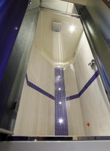 a shower with a blue and white tile floor at Boutique Hotel Calzavecchio in Casalecchio di Reno
