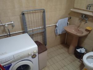 a small bathroom with a washing machine and a sink at Sobe Nevenka in Vrnjačka Banja