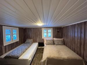 a bedroom with two beds and a ceiling at Beautiful Cabin by Mjøsa. in Stange