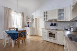 a kitchen with white cabinets and a table with a blue table cloth at Chalupa Kolowrat in Horka