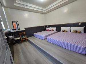 a hotel room with two beds and a mirror at Peace 28 B&B in Jincheng