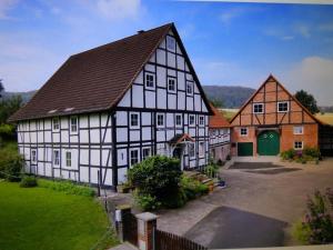 un gran edificio blanco y negro con una puerta verde en FeWo Deitlevser Hof en Emmerthal