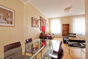 a living room with a glass table and chairs at Roberta Apartment Fontana di Trevi in Rome