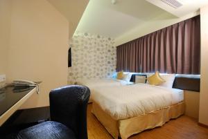 una habitación de hotel con 2 camas y una silla en 欣欣旅店, en Taipéi