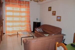 uma sala de estar com um sofá e uma mesa de vidro em Grazioso appartamento vicino al mare em Giardini Naxos