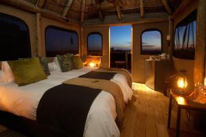 a bedroom with two beds in a room with windows at Addo Elephant Safari Lodge - Bellevue Forest Reserve in Paterson