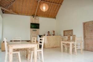 a man sitting at a table in a room with tables and chairs at Bingin Garden Uluwatu in Uluwatu