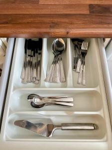 a drawer filled with silver utensils in a cabinet at City Home Lahti in Lahti