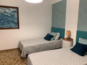 a room with two beds and a picture on the wall at Sagunto 2 in Sagunto