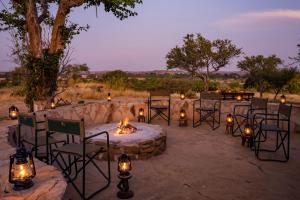 a group of chairs and a fire pit with candles at Shalimpo Safari Home in Lentswelemoriti