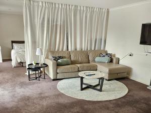 a living room with a couch and a table at Guest Suite in Duffy in Weston Creek