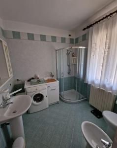ein Bad mit einer Dusche und einer Waschmaschine in der Unterkunft Reitia Guest House in Campagna Lupia
