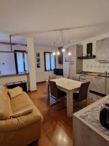 eine Küche und ein Wohnzimmer mit einem Tisch und einem Sofa in der Unterkunft Reitia Guest House in Campagna Lupia