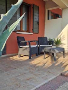 dwa krzesła i stół przed domem w obiekcie Reitia Guest House w mieście Campagna Lupia