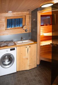 a kitchen with a sink and a washing machine at Rahkis Lodge Saariselkä in Saariselka