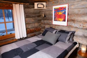 ein Schlafzimmer mit einem Bett in einem Blockhaus in der Unterkunft Rahkis Lodge Saariselkä in Saariselkä