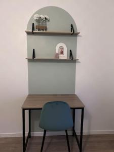 a table with a blue chair and shelves at La petite maison in Brienon-sur-Armançon