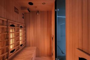 a walk in closet with wooden walls and a glass door at A O G prestige Relax Max SPA SAUNA in Algolsheim