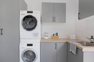 a kitchen with two washing machines and a sink at The Elements l Air l 4 Stunning Apartments each with Private Outdoor Dining l Walk to the Beach l Pet Family and Event Friendly l Wifi l Netflix l Outdoor Shower l Communal BBQ Pavilion and Lawn Area l in Christies Beach