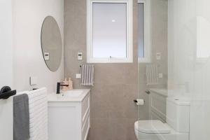 a bathroom with a sink and a toilet and a window at The Elements l Air l 4 Stunning Apartments each with Private Outdoor Dining l Walk to the Beach l Event Friendly l Wifi l Netflix l Outdoor Shower l Communal BBQ Pavilion and Lawn Area l in Christies Beach +15 photos
