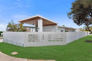 a white fence in front of a house at The Elements l Air l 4 Stunning Apartments each with Private Outdoor Dining l Walk to the Beach l Pet Family and Event Friendly l Wifi l Netflix l Outdoor Shower l Communal BBQ Pavilion and Lawn Area l in Christies Beach