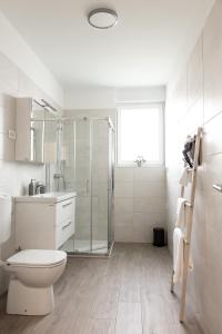 a white bathroom with a toilet and a shower at Hiša Bianca apartments in Koper +11 photos