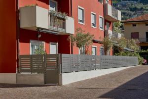 een hek voor een rood gebouw bij Residenza ai Ferrari - Appartamento Lilium in Riva del Garda
