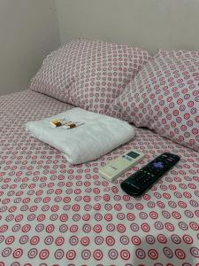 a bed with a remote control on top of it at Pousada Duna Village in Barreirinhas