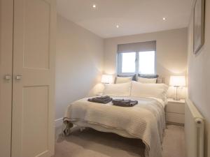 a bedroom with a bed with two robes on it at 2 Bed in Cartmel 73154 in Cartmel
