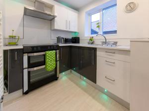 a kitchen with white cabinets and a black stove top oven at 1 Bed in Harrogate 66981 in Knaresborough