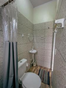 a bathroom with a toilet and a shower and a sink at Pousada Duna Village in Barreirinhas
