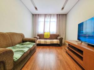 a living room with a couch and a flat screen tv at Europe Garden Apartment, 3 quartos in Juiz de Fora