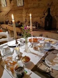 a table with candles and plates and flowers on it at La Malposte in Reviers