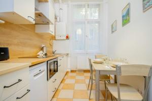 ブダペストにあるRiverside homeのキッチン(白いキャビネット、テーブル、椅子付)