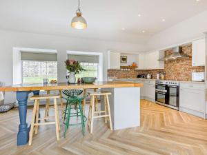 a kitchen with a large island with stools in it at 3 Bed in Glen Clova 75284 in Kirriemuir