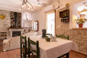 cocina y comedor con mesa y sillas en Casa rural Vall de Gallinera con Chimenea, piscina y jacuzzi DIANIA en Patró