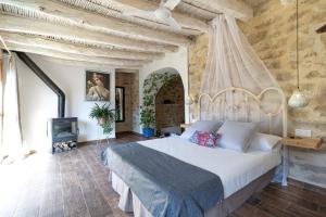 1 dormitorio con 1 cama grande y chimenea en Casa rural Vall de Gallinera con Chimenea, piscina y jacuzzi DIANIA, en Patró