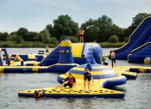 a group of people playing on an inflatable raft in the water at Holly Cottage, Coln St Aldwyns, Cotswolds in Cirencester
