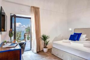 a bedroom with a bed and a view of the ocean at GOCCE VILLAS - Villa Degli Dei Waterfront Villa in Vico Equense