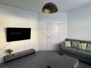 Urban Retreat في Great Coates: غرفة معيشة مع أريكة وتلفزيون بشاشة مسطحة